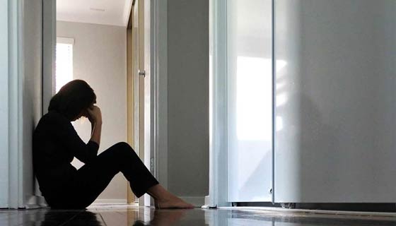 Depressed woman sitting on floor