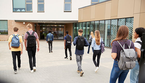 teens walk towards school