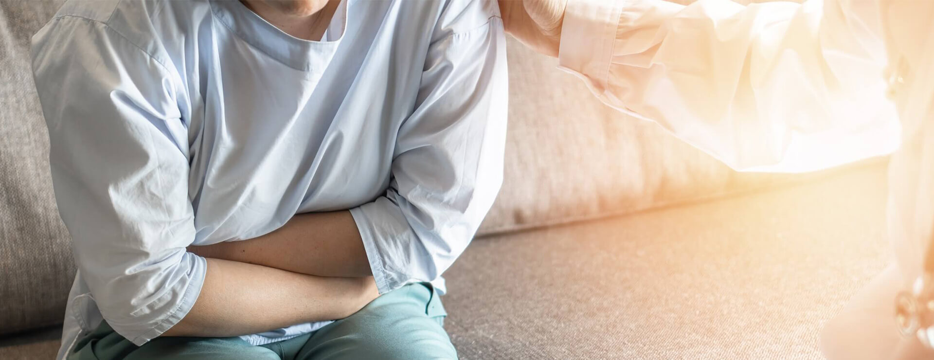 A woman experiencing abdominal pain during a medical exam.