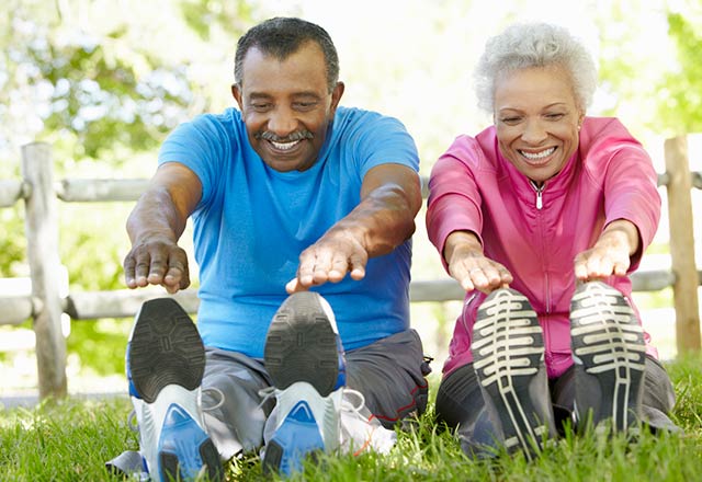 An active senior couple stretch before going on a jog.