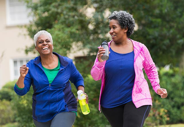 Senior women happily jog together.