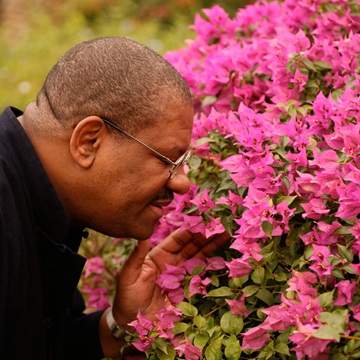 Man smelling bright pink flowers