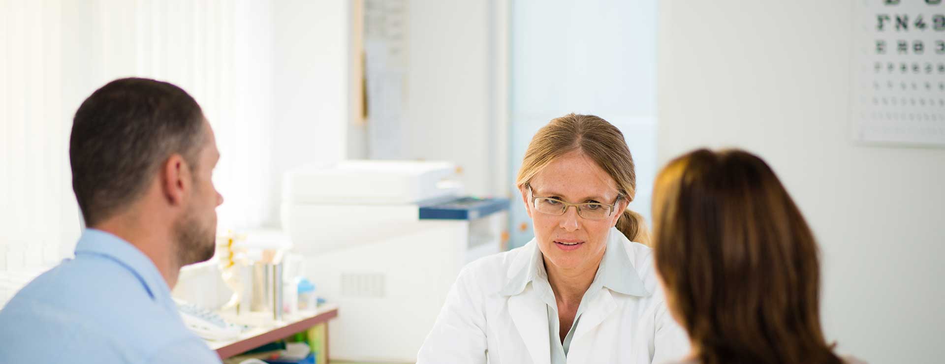 Doctor discussing parkinson's diagnosis with middle-aged couple