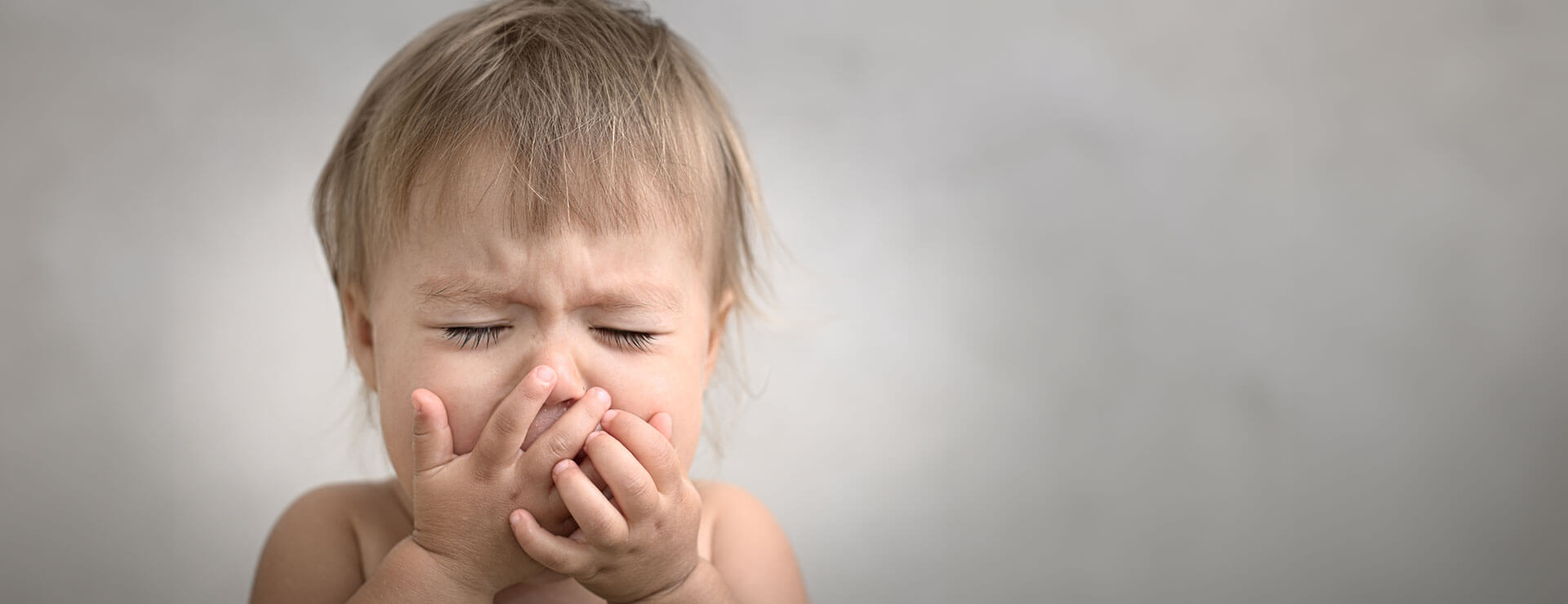 small child covers mouth