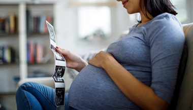 Pregnant person looking at fetal ultrasounds at home
