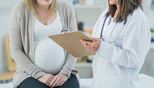 Pregnant woman speaking with a doctor