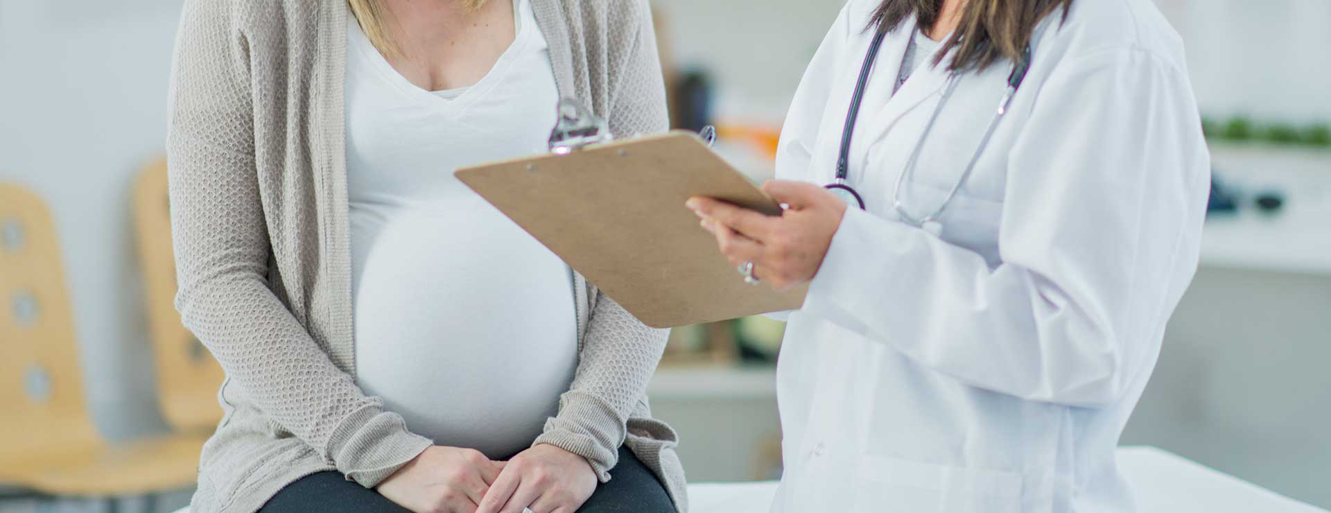 Pregnant woman speaking with a doctor
