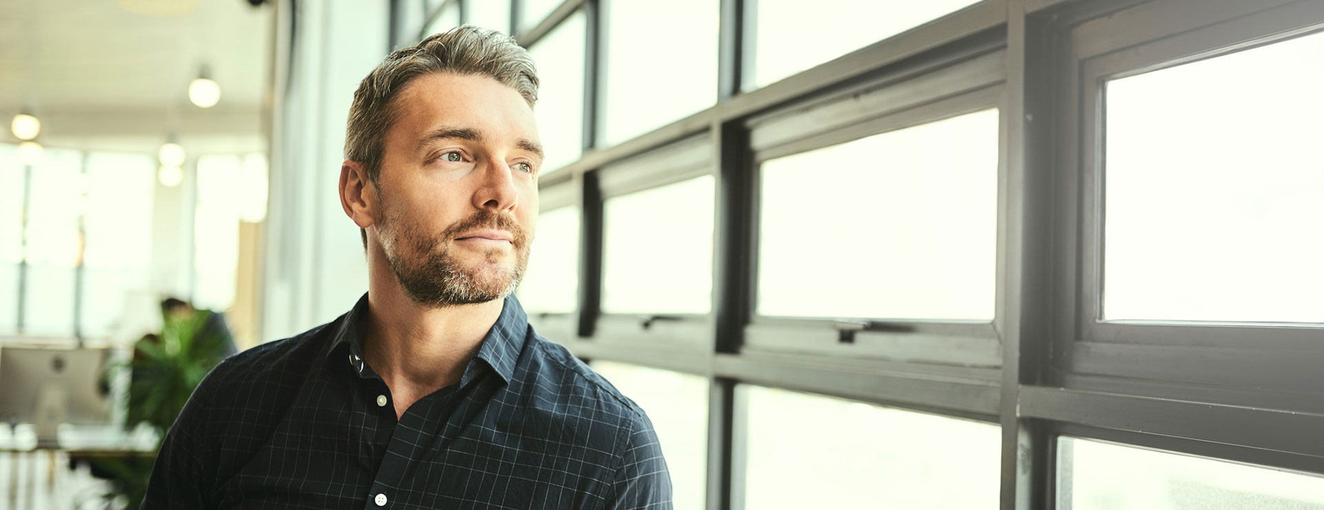 a middle aged man looking out a window