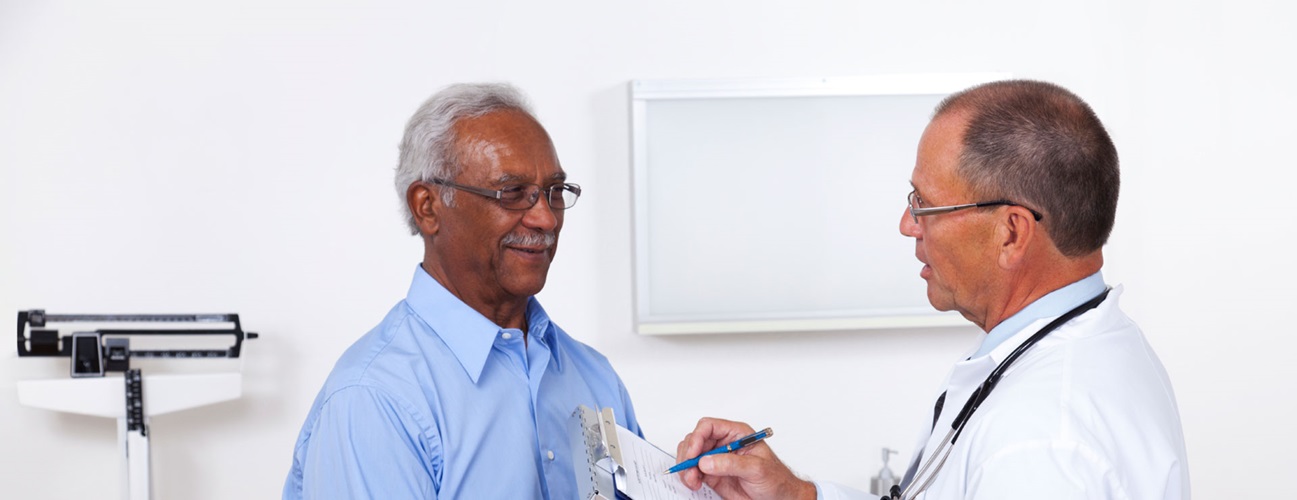 A senior man talks with his doctor during a medical exam.