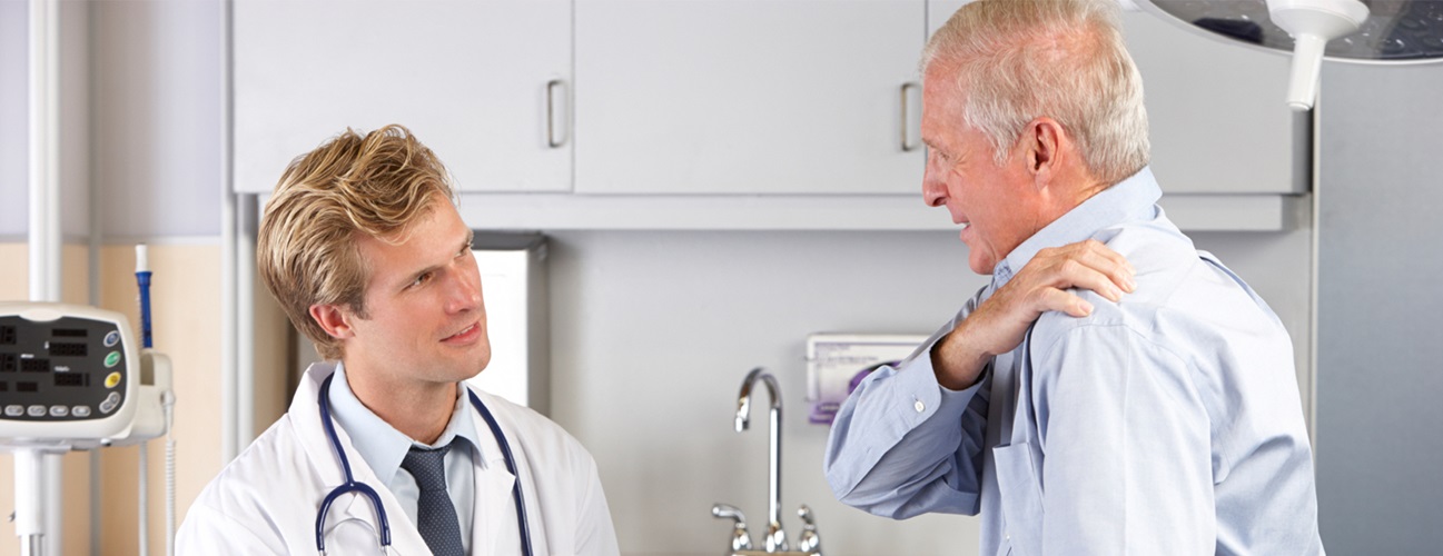 man holding shoulder talking to doctor