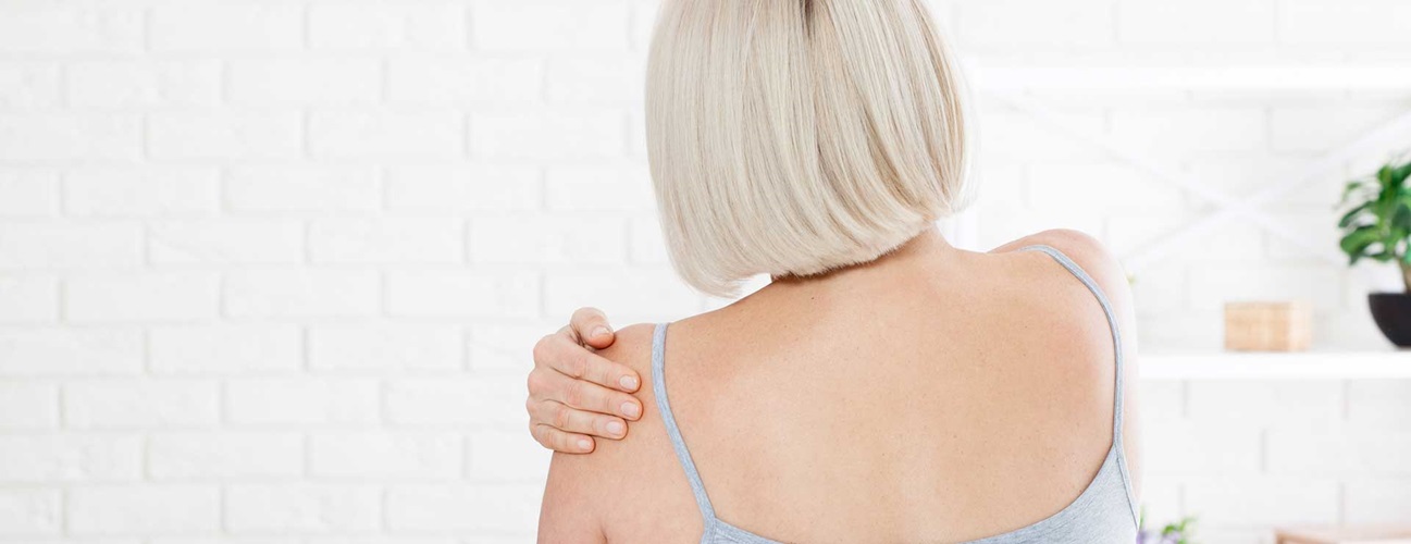 Woman holder her shoulder in pain