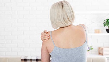 Woman holder her shoulder in pain