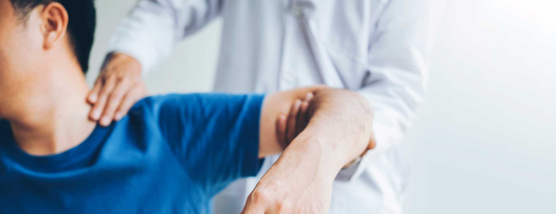 specialist examining patient's shoulder
