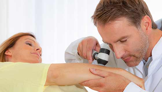 doctor checks patient's skin
