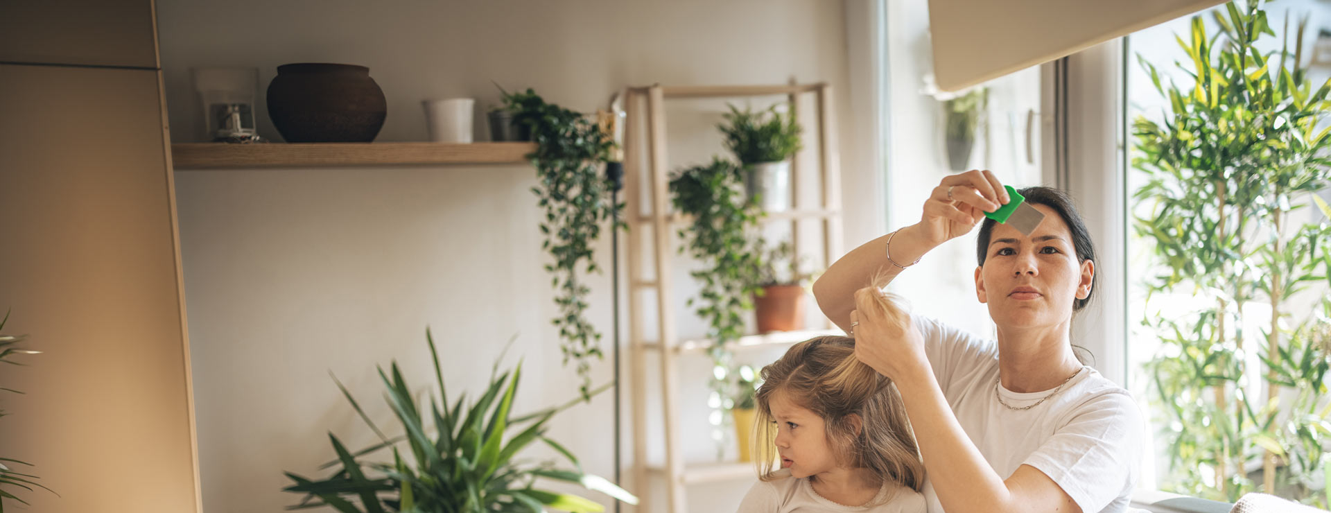 Mother checking her daughters hair for lice