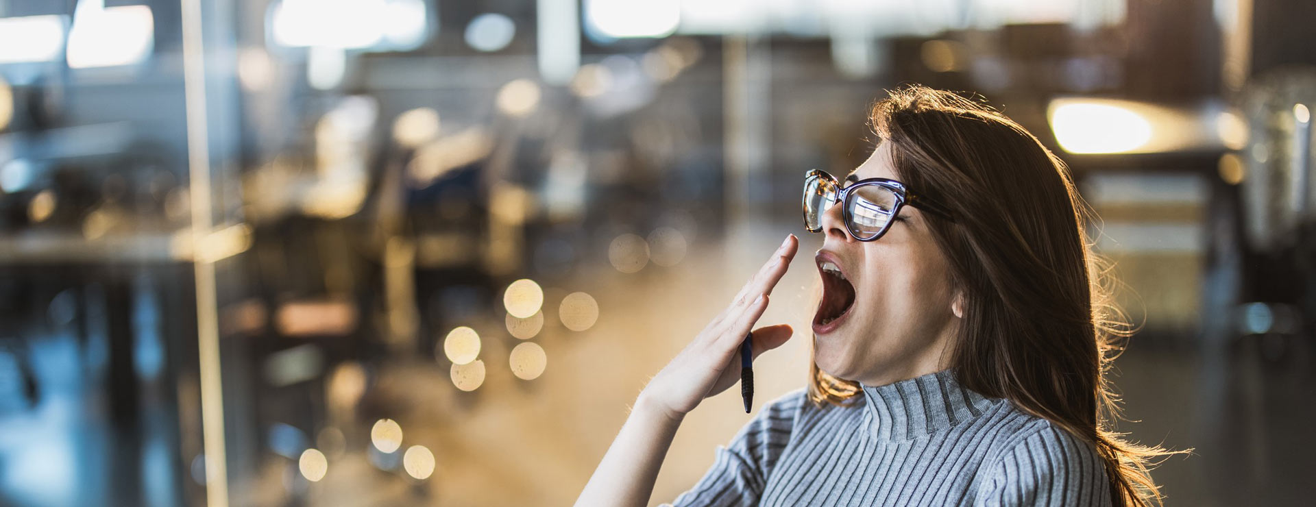 Woman yawning at work in her office
