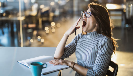 Woman yawning at work in her office