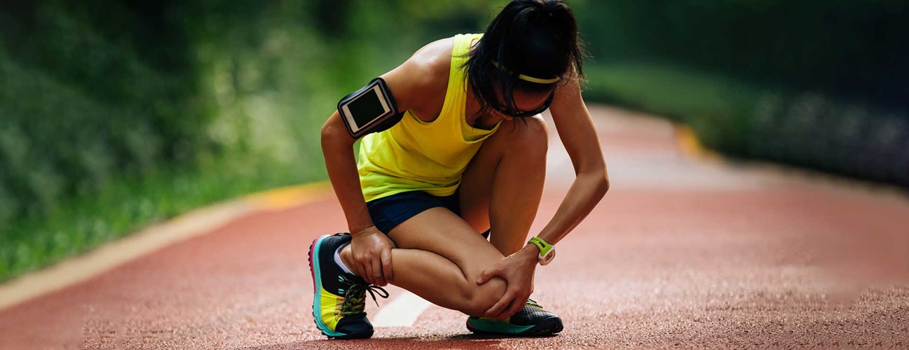 woman runner holding her knee in pain