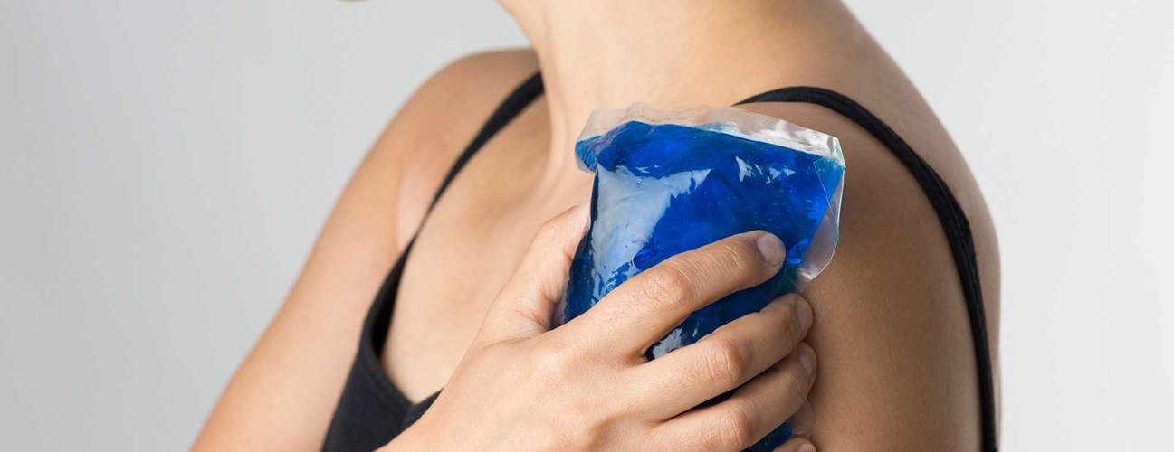 Woman holding an ice pack over her shoulder