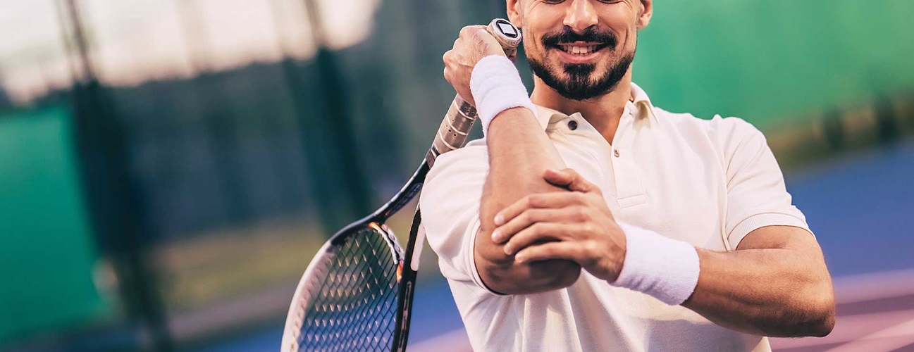 Tennis player holding elbow in pain
