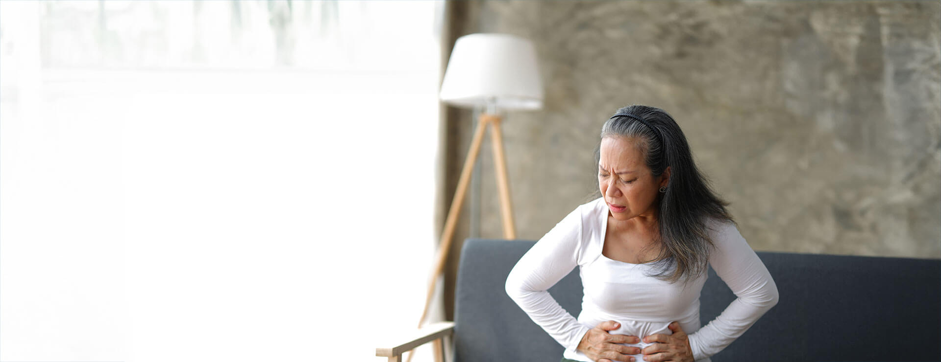a woman with collagenous and lymphocytic colitis holds her stomach