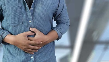 A man clutches his stomach in pain.