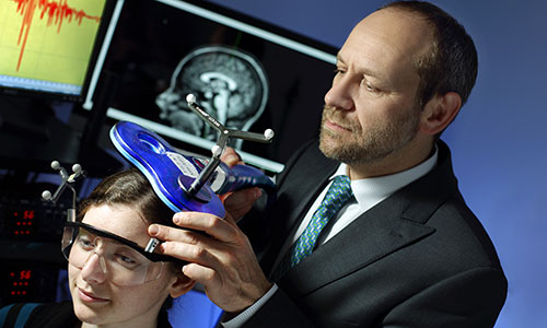 Dr. Pablo Celnik demonstrates the use of noninvasive brain stimulation on a patient