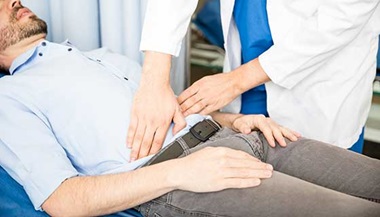 man having pelvic area checked by doctor