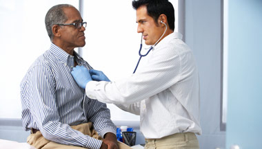 Doctor using stethoscope on male patient