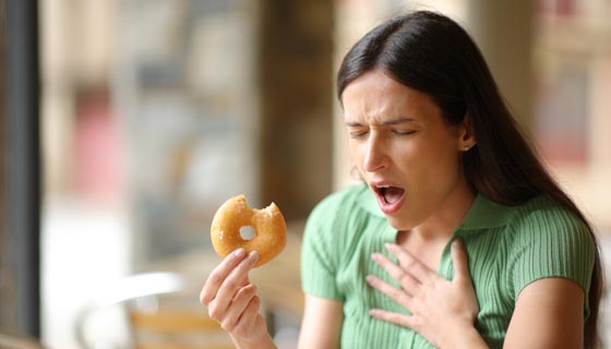 Woman choking on a donut