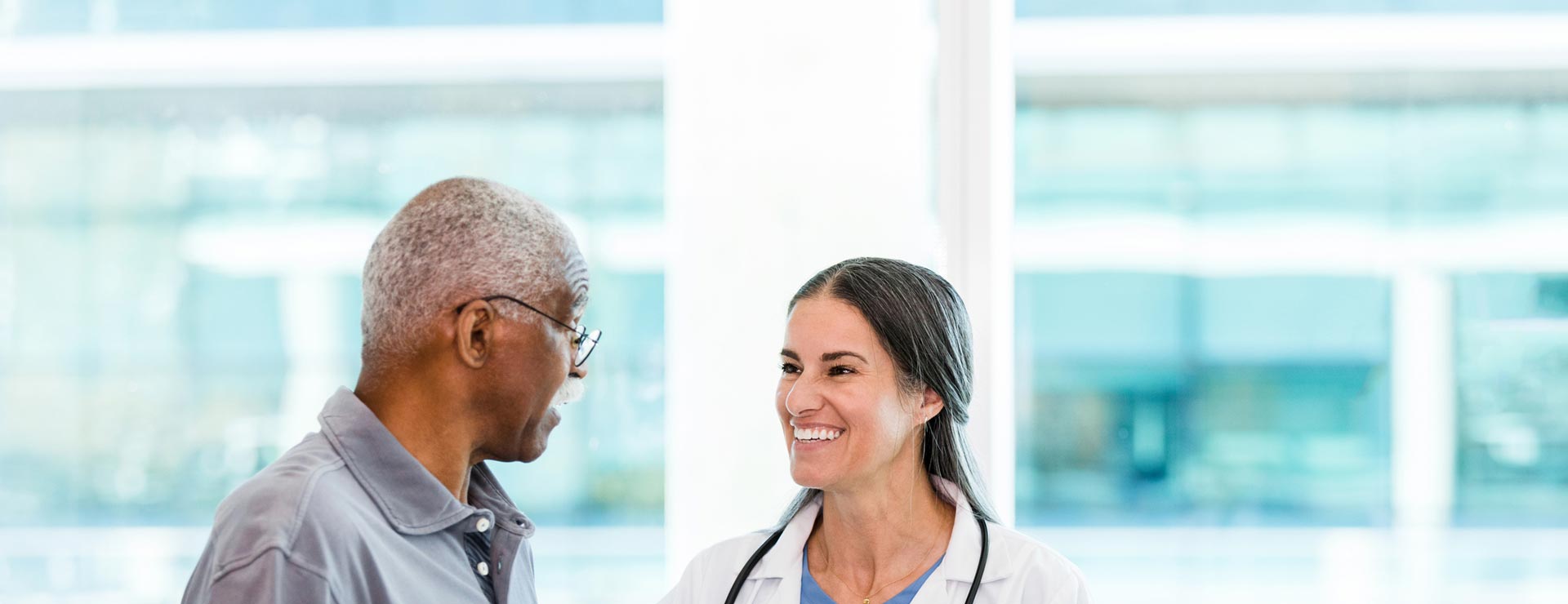 Doctor conversing with elderly patient prior to surgery