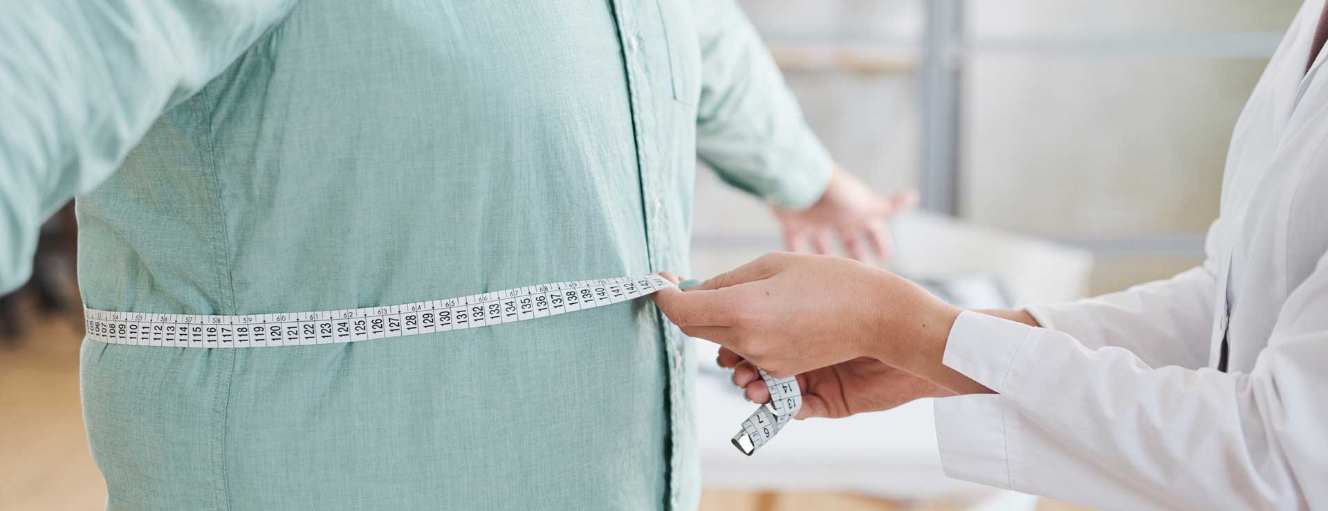 doctor measuring mans waist