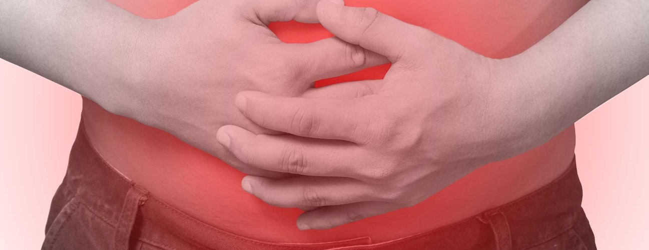 A person holds their stomach in pain.