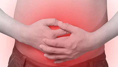 A person holds their stomach in pain.