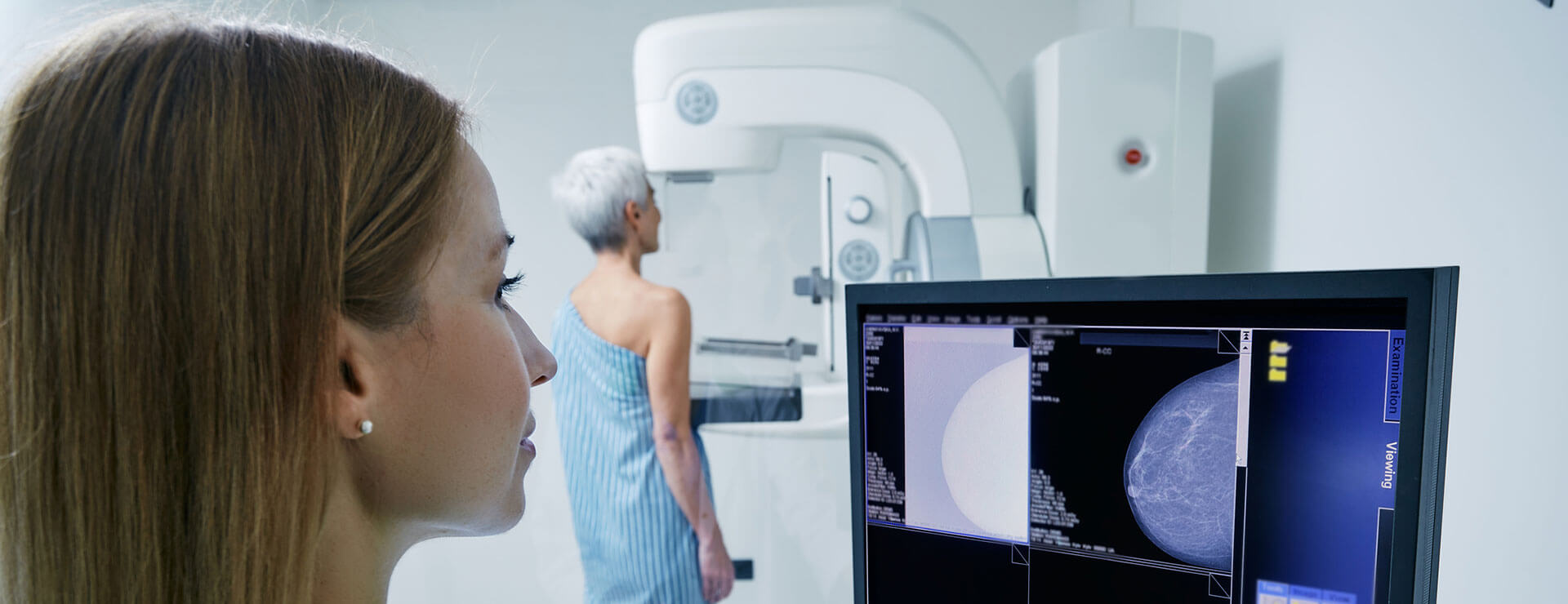 A woman has breast imaging done while doctor reviews the images