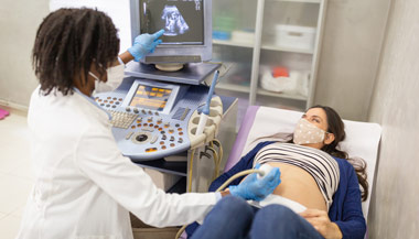 Doctor performing sonogram for pregnant patient