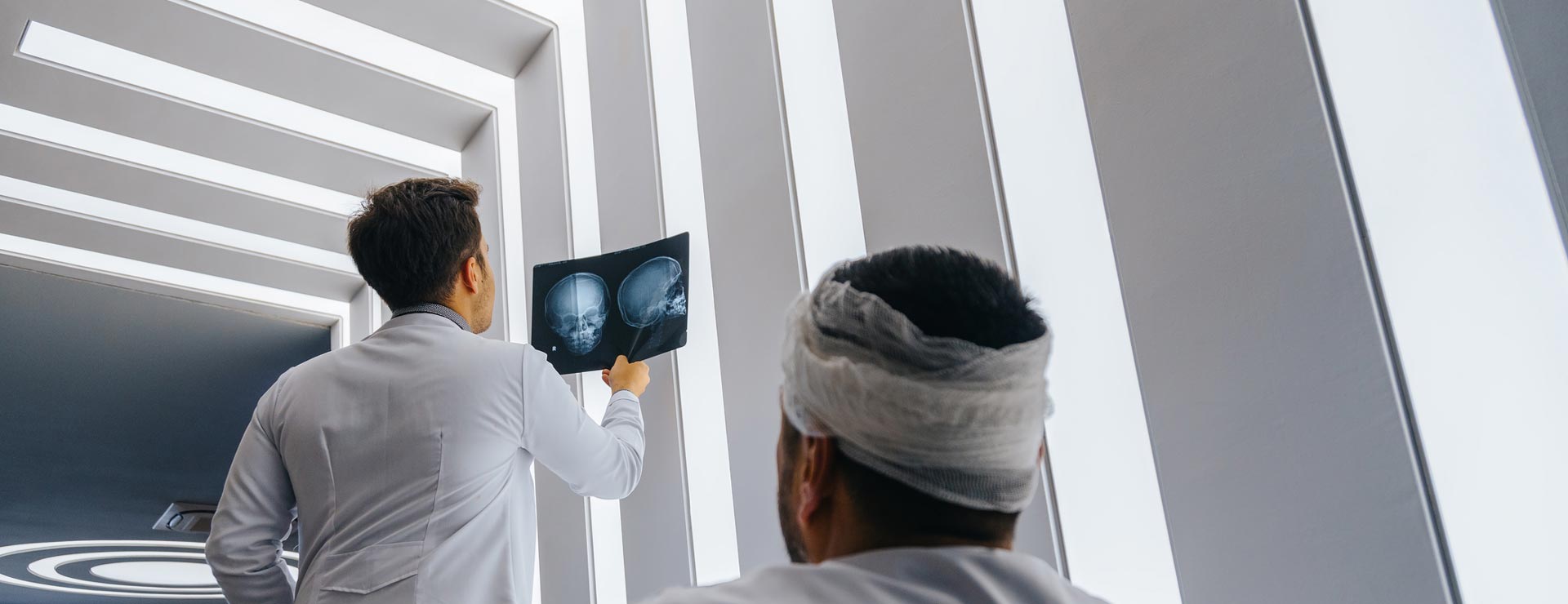 Man with a head injury watching a doctor look at his head x-rays