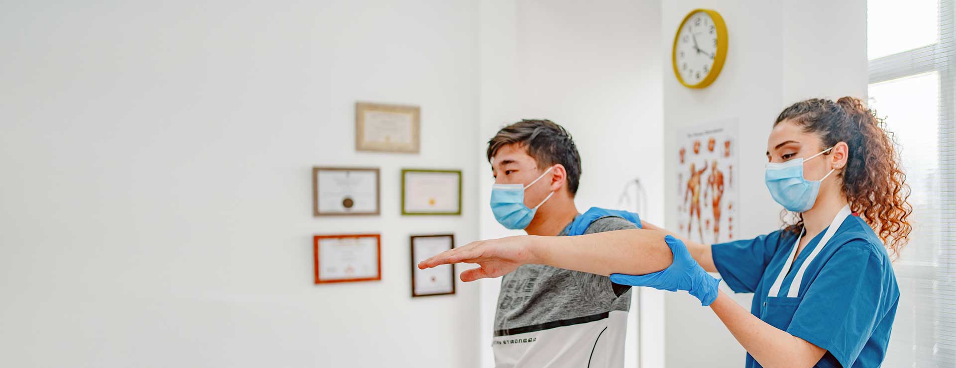 Therapist examines a patient's shoulder as he recovers from a nerve transfer