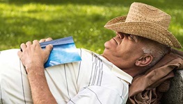 senior man with hat napping outdoors