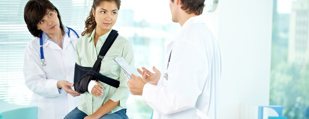 Patient wearing sling discussing treatment plan with doctors