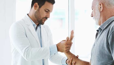 Doctor examining a patient's hand.