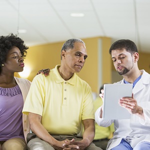 Male patient and his daughter listen to doctor's instructions
