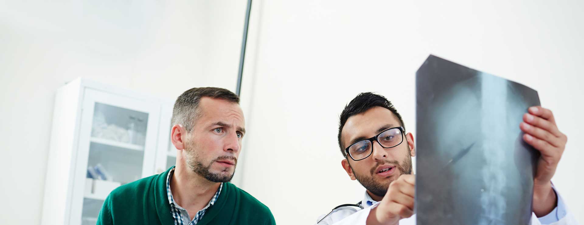 Doctor discussing spine x-rays with patient