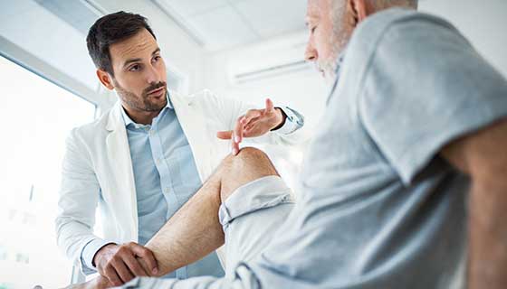 Doctor pointing to patient's knee.