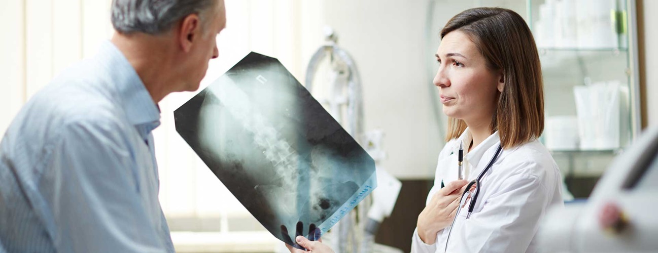 Doctor discussing spine x-ray with patient.