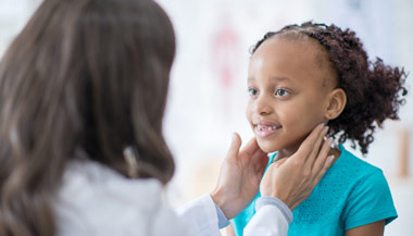 Doctor examining a child patients neck