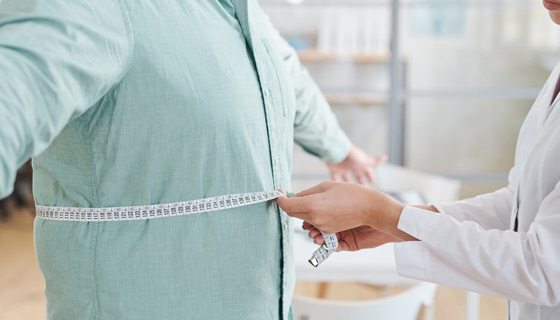 Doctor measuring a mans stomach
