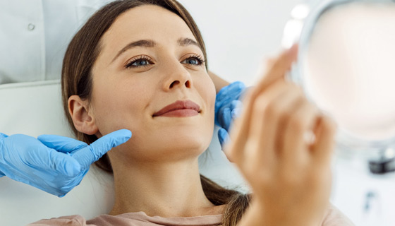 Woman smiling at her reflection in a mirror