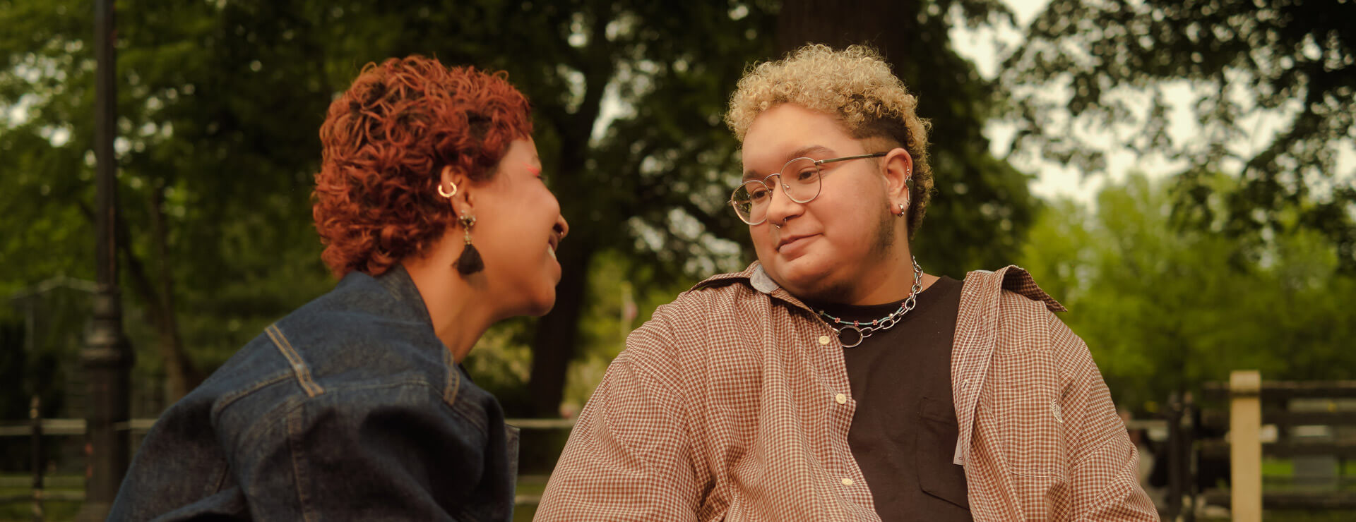 Trans couple smiles at each other and holds hands.