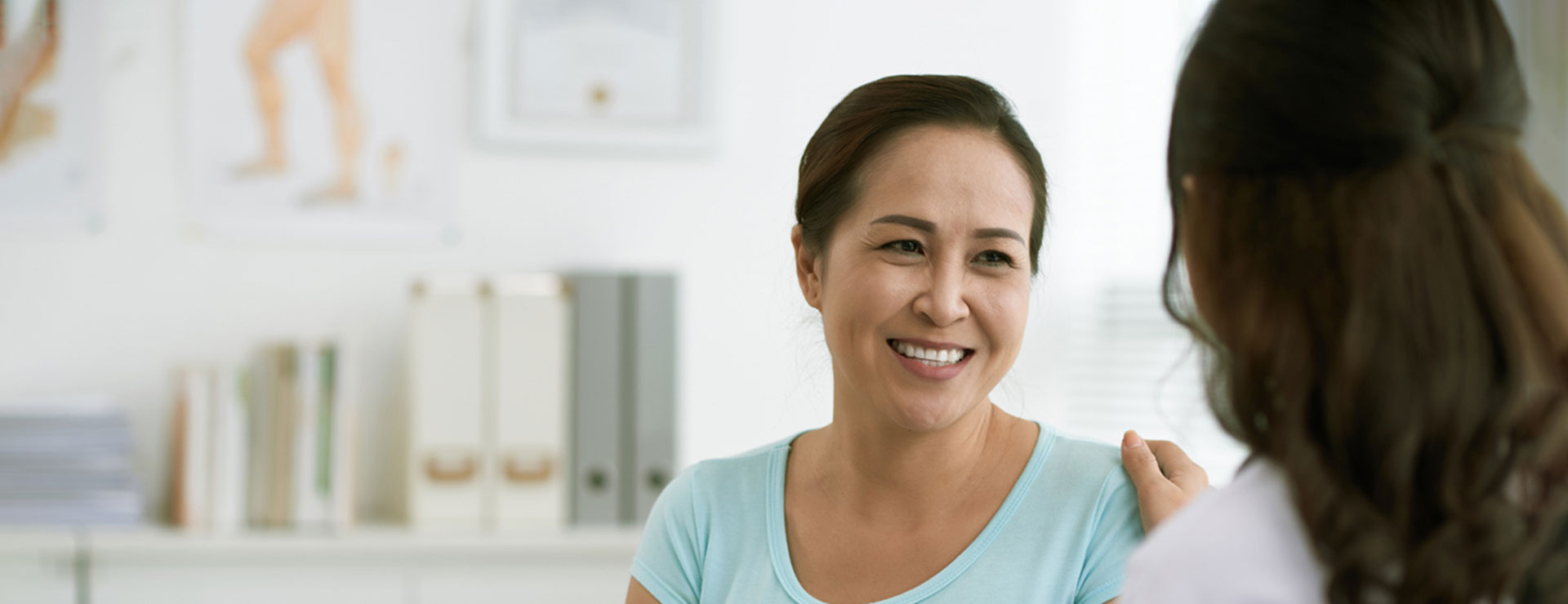 A woman smiles while talking to her doctor.